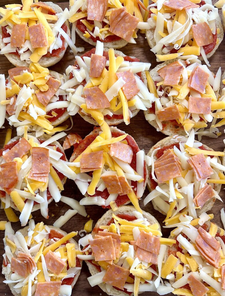 mini bagels with pizza sauce, shredded cheese and pepperoni on top