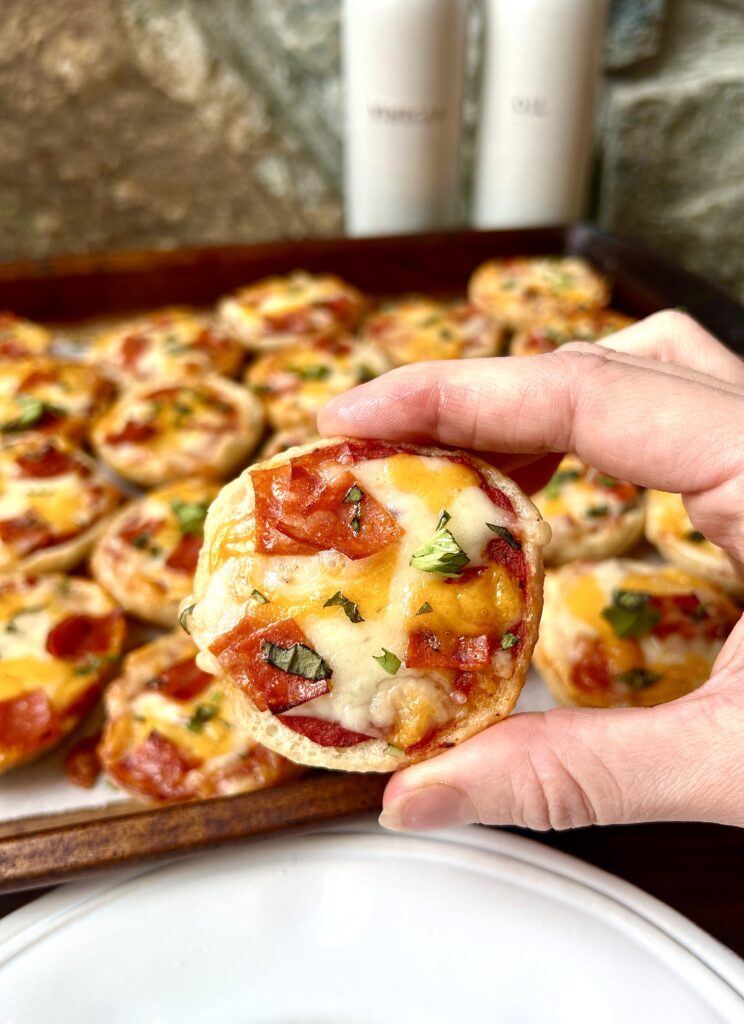 a mini bagel with melted cheese and pepperoni