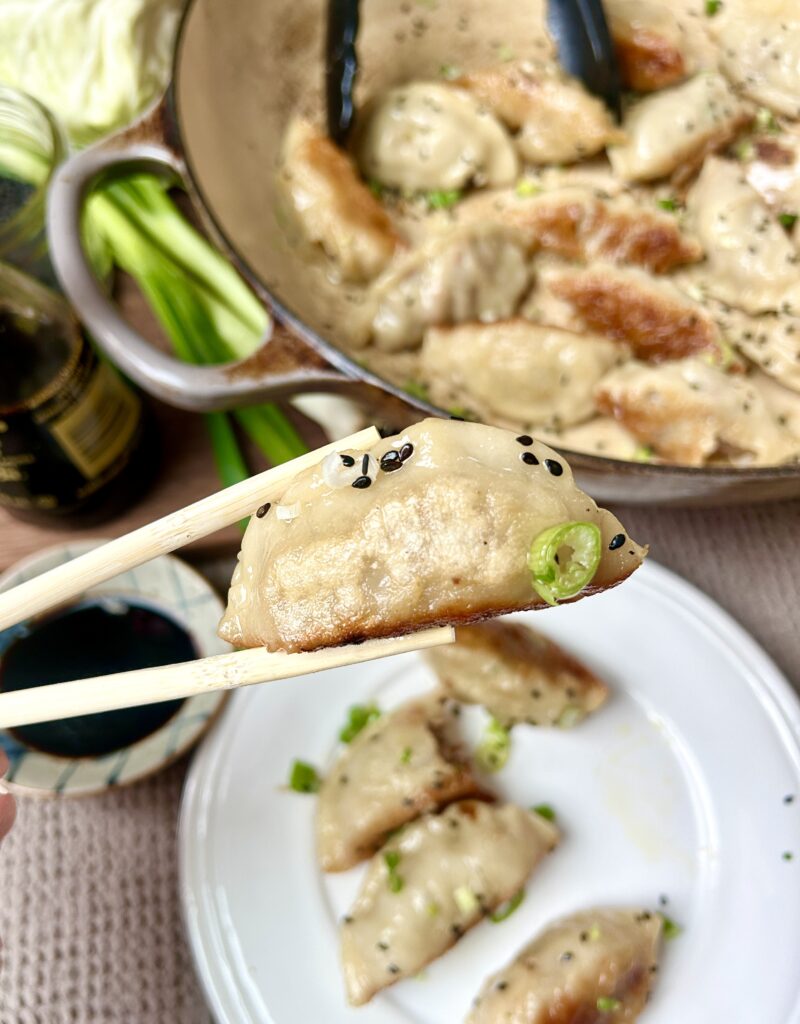 a dumpling being held with chopsticks