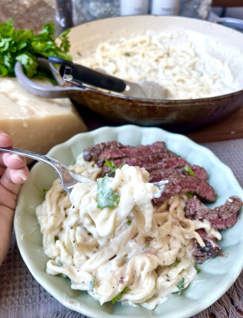 a fork full of creamy alfredo pasta