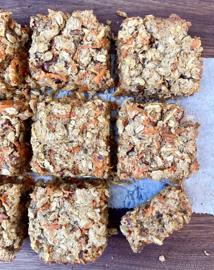 oatmeal squares with carrots and apples on a wood board