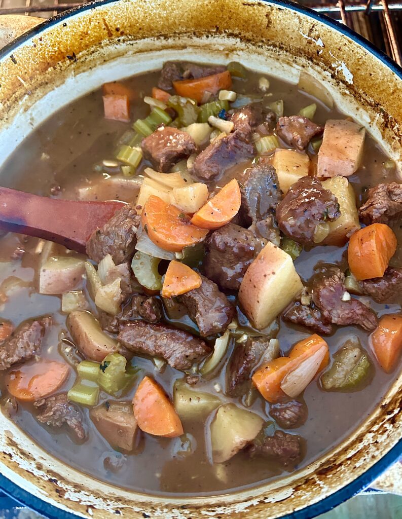 a large pot of stew with meat, potatoes and vegetables