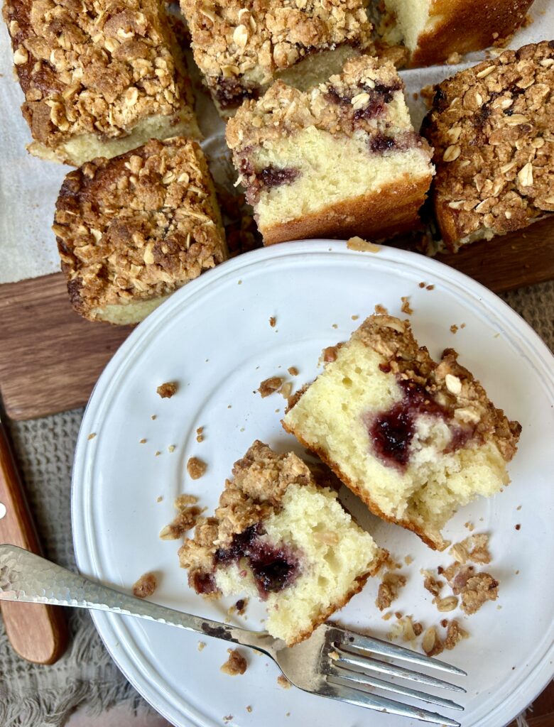 a white plate with a slice of jam coffee cake on it