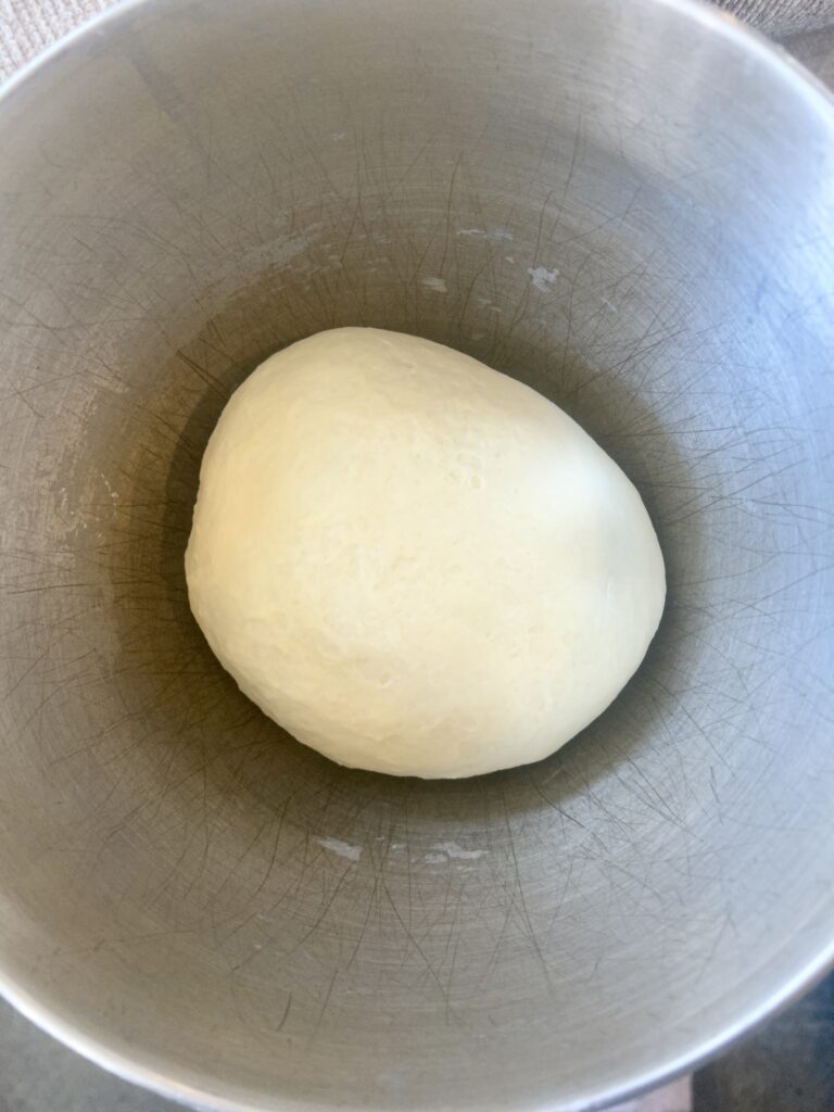 a stainless bowl full of dough