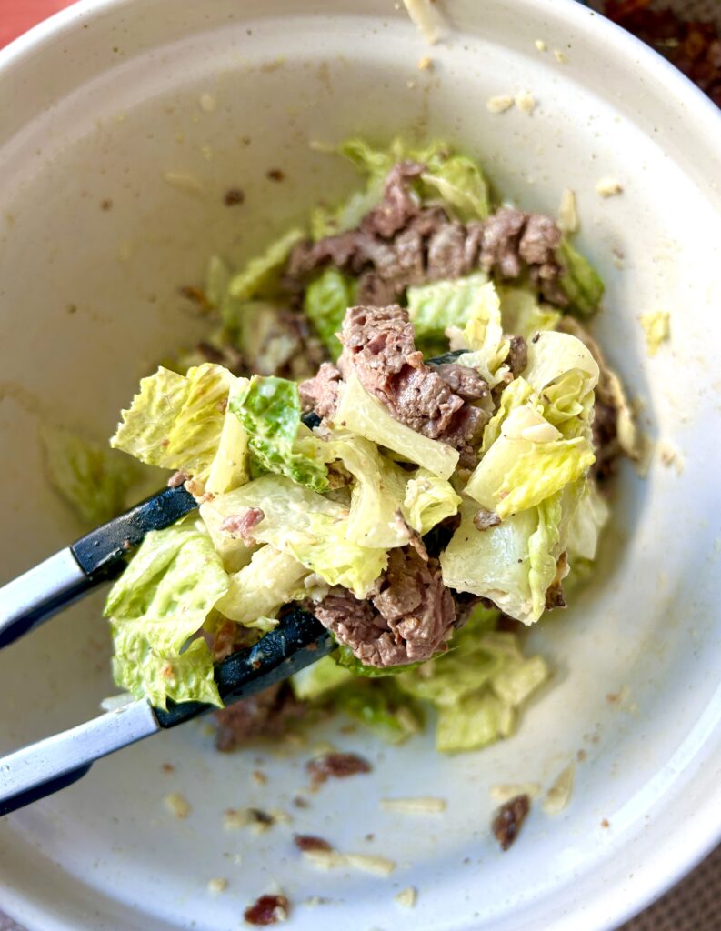 a bowl of steak caesar salad