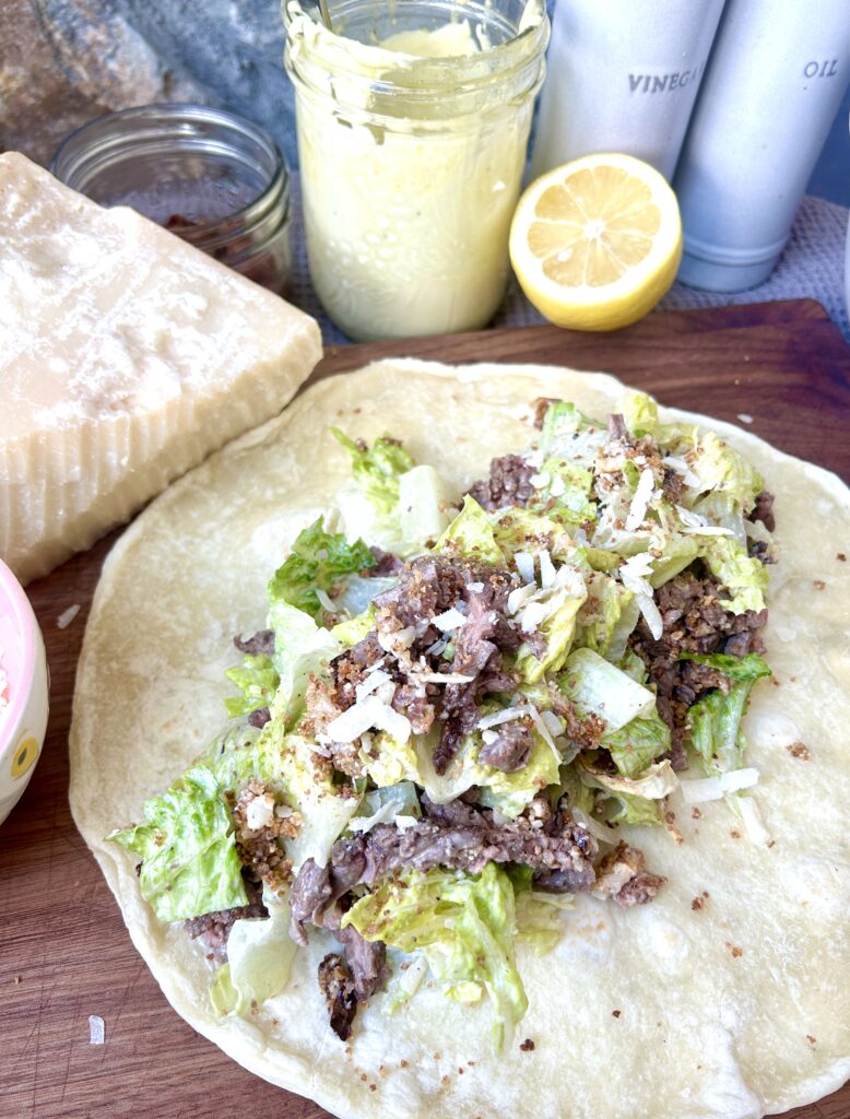 a tortilla with steak salad on top 