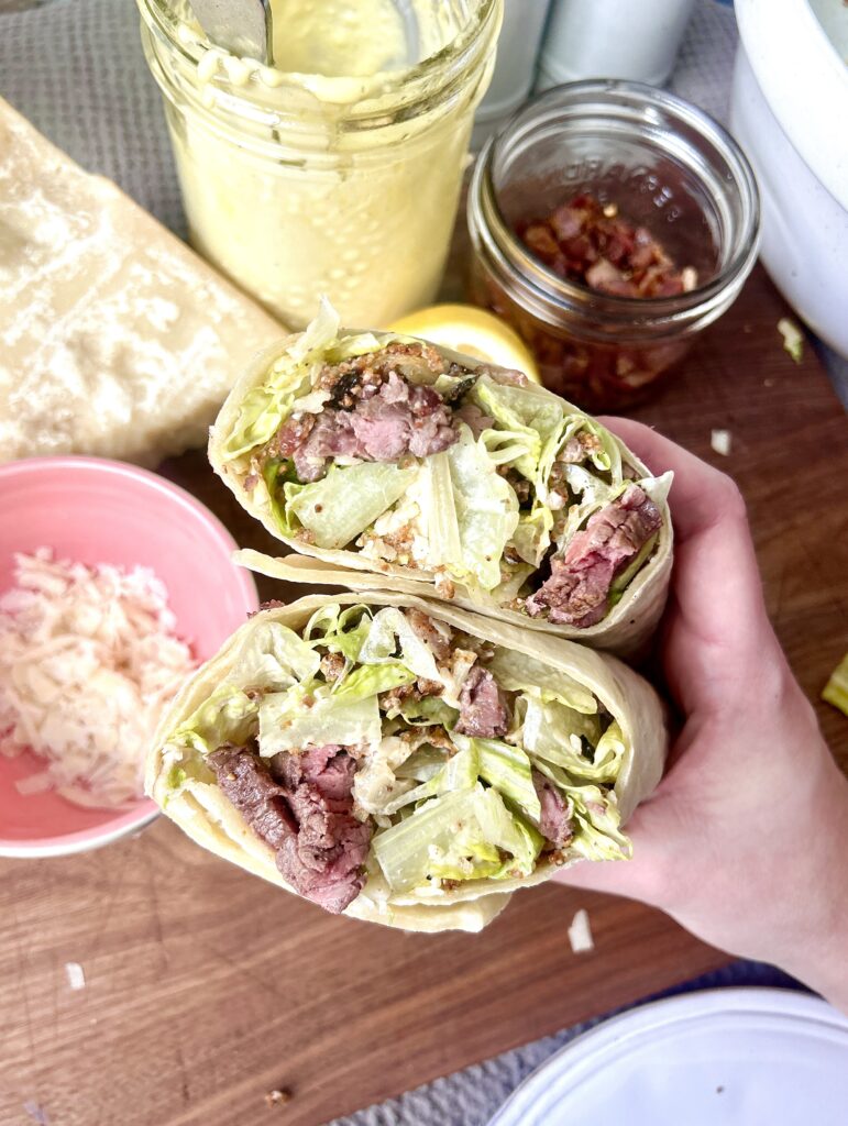 a warp with steak caesar salad inside 