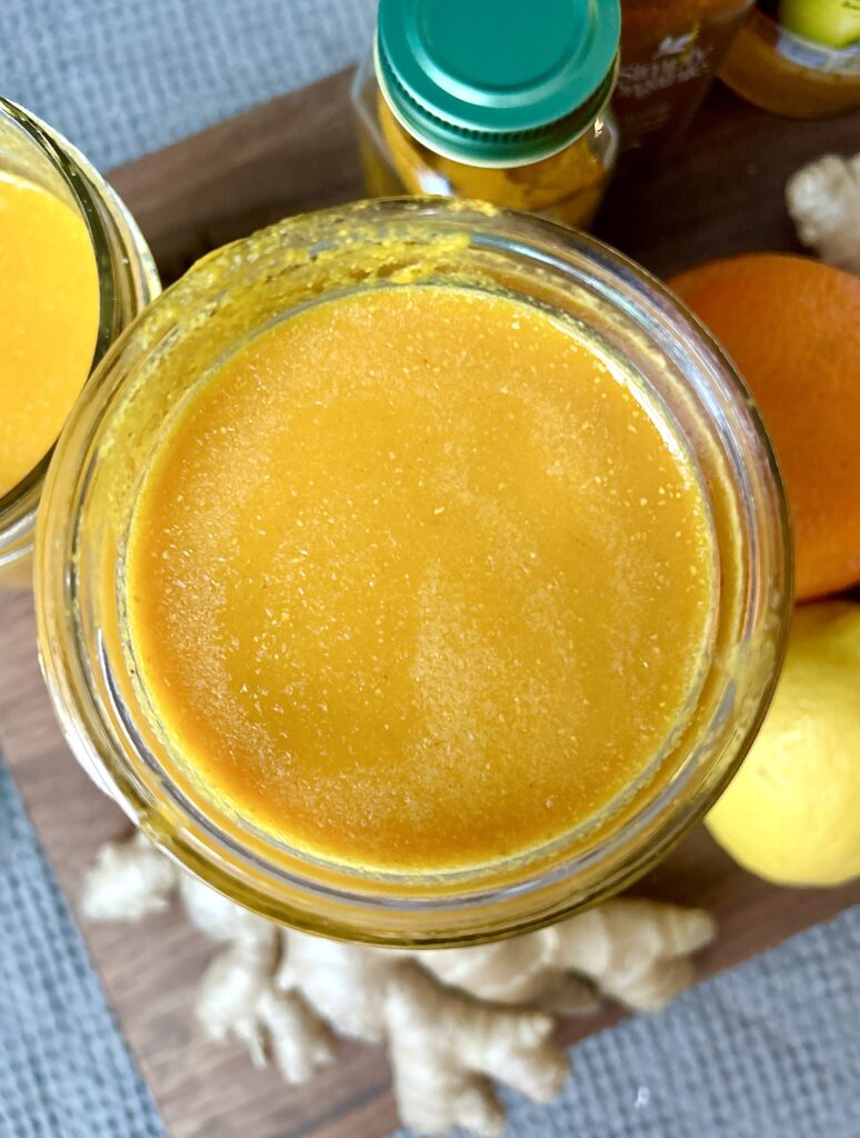 a jar of juice, made from ginger, oranges and lemon