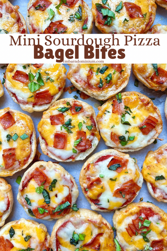 mini pizza bagels on a baking sheet with pepperoni and cheese