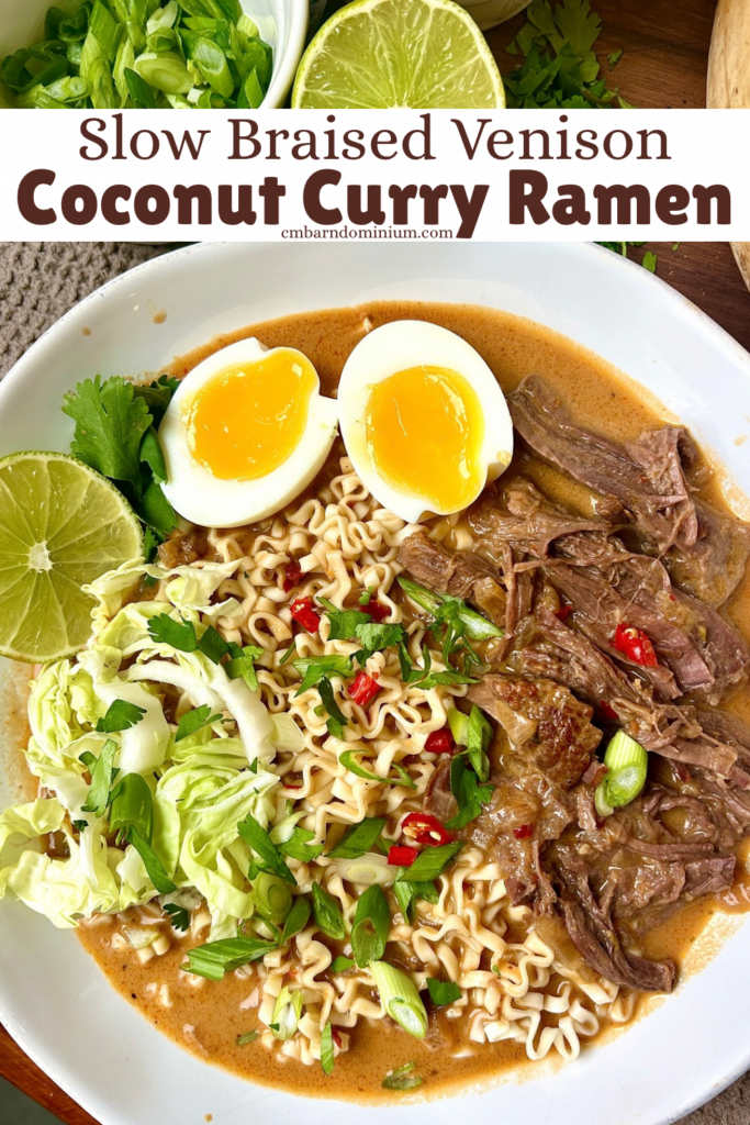 a white bowl of curry ramen noodles with a soft boiled eggs, cabbage and shredded meat