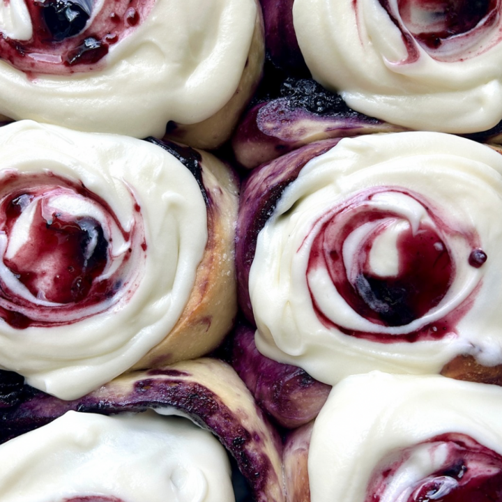 blueberry cinnamon buns with icing and blueberry swirl on top