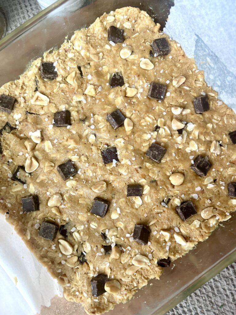 unbaked cookie dough with chocolate chunks in a square baking dish