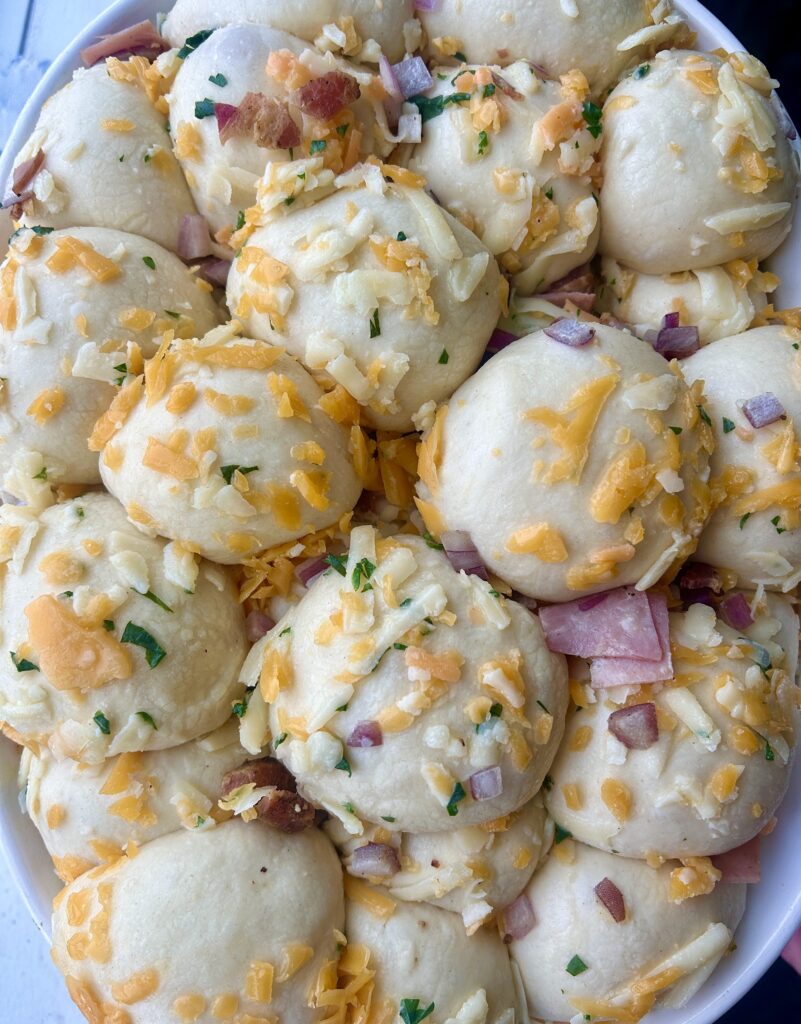bread dough balls with meat and cheese in a baking dish