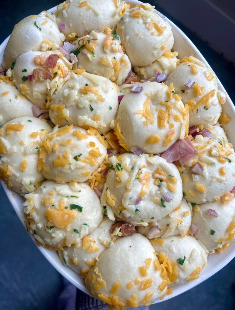 dough balls covered in cheese in a baking dish