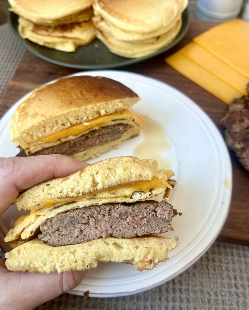 a breakfast sandwich with sauce cut in half