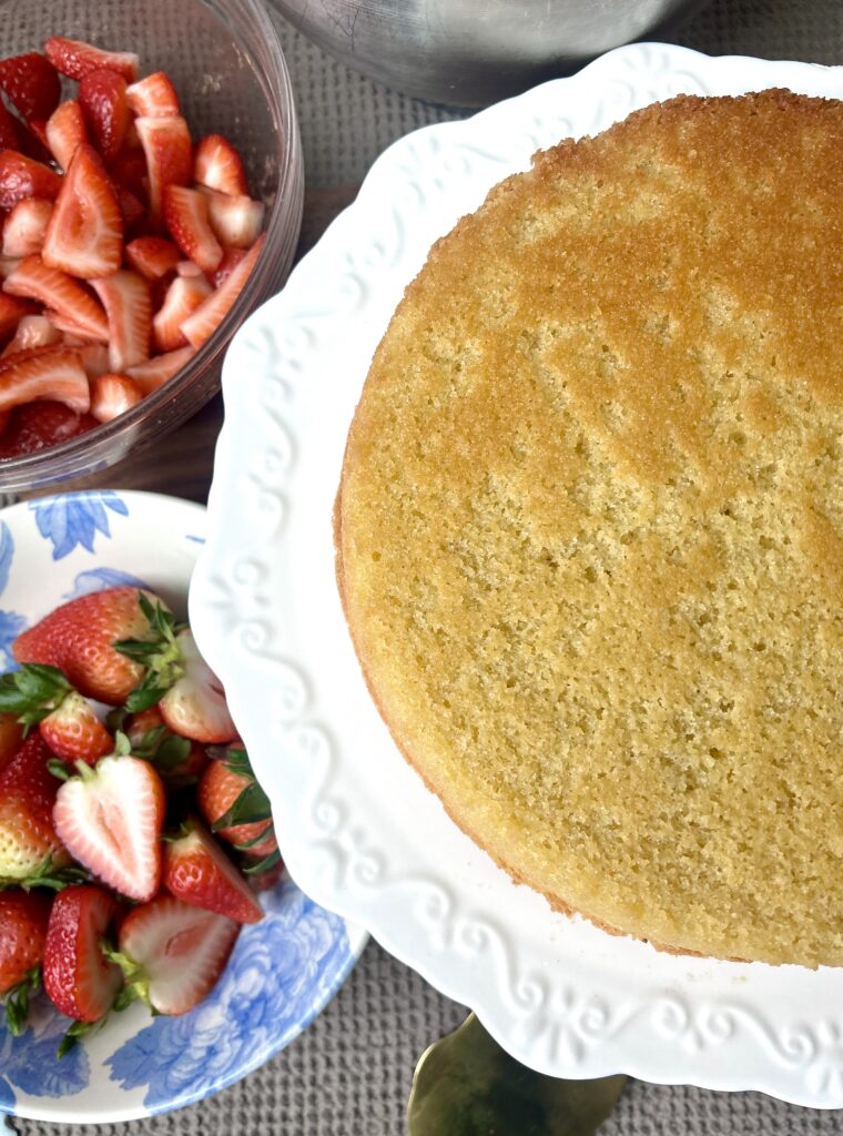 a vanilla cake on a white cake stand