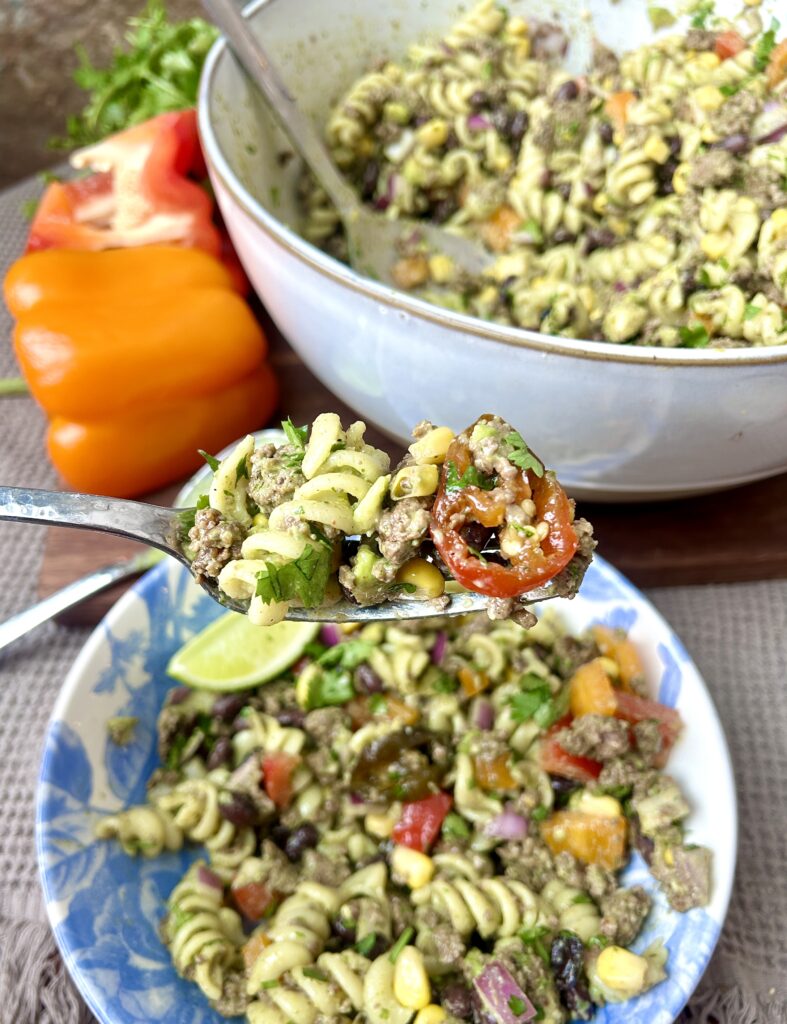 a blue and white bowl of cilantro lime pasta salad with venison