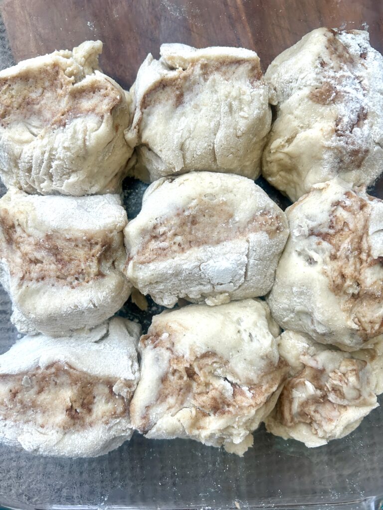 unbaked cinnamon buns in a glass baking dish