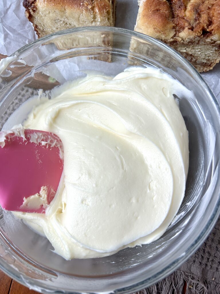 a glass bowl of cream cheese icing
