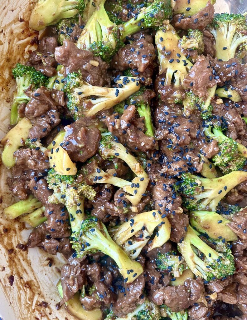 strips of venison steak with broccoli and soy sauce in a skillet
