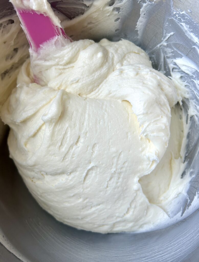 a stainless steel bowl of cream cheese icing
