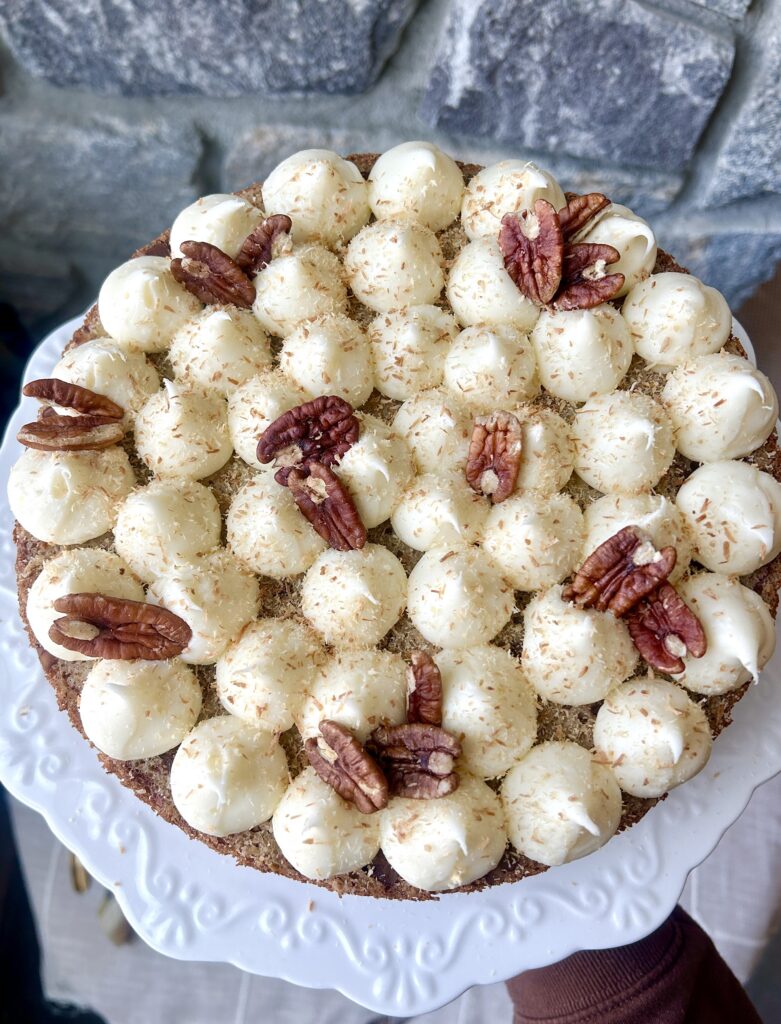 a pineapple, banana and pecan cake with pecans and icing on top