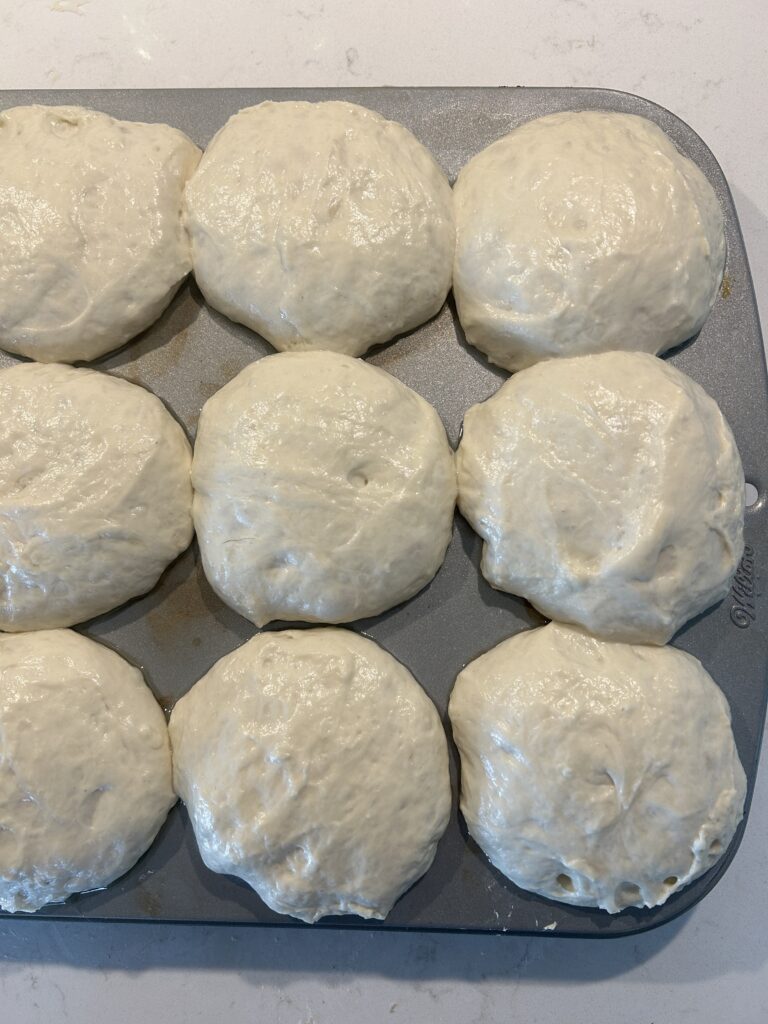 risen dough in a muffin tin