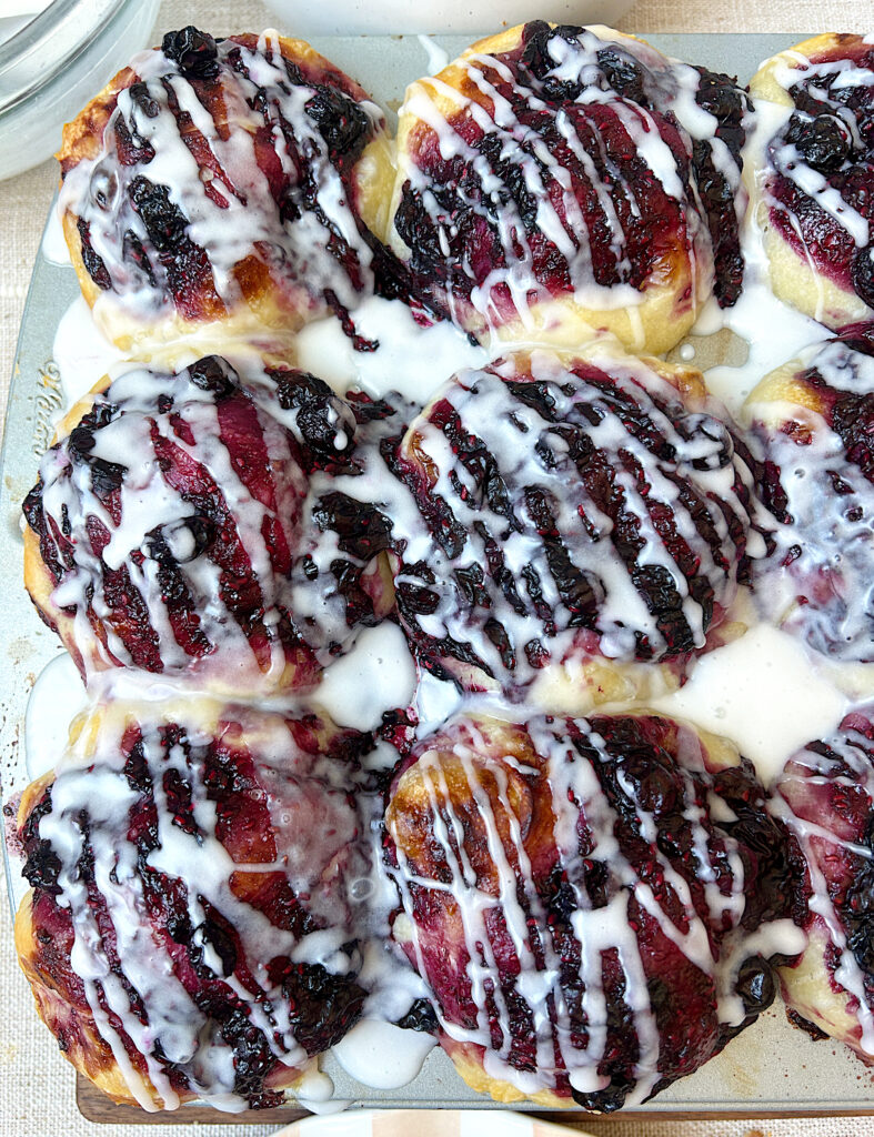 a muffin tin with berry sourdough muffins