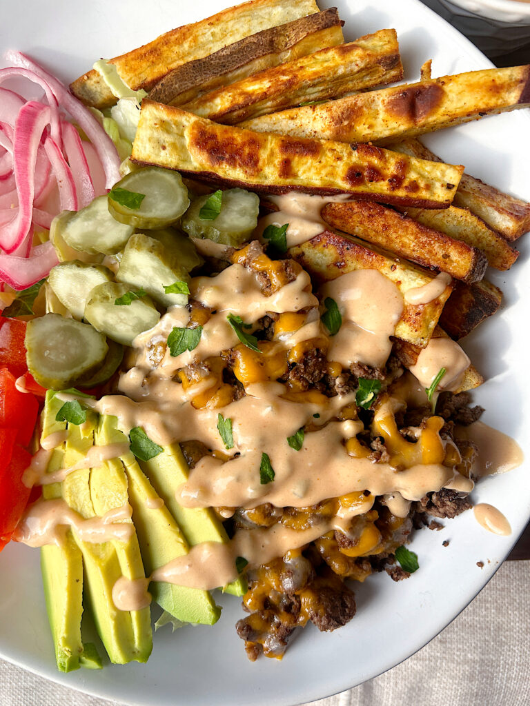 dinner bowl with crispy fries, ground meat, pickles and burger sauce