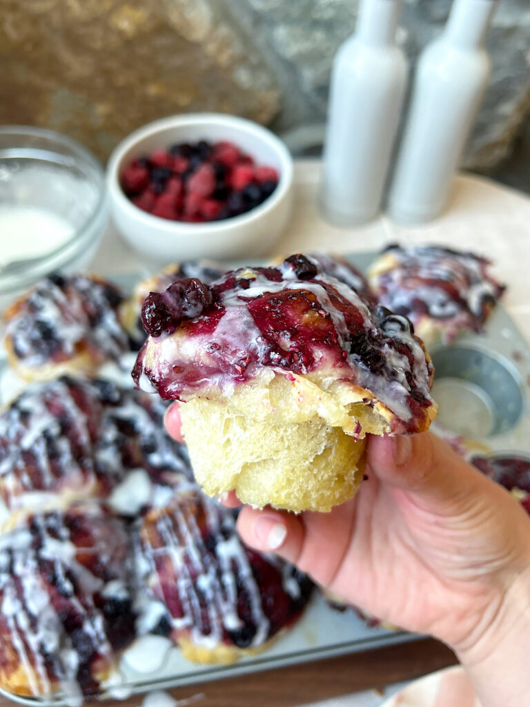 a sourdough muffin with berries and vanilla glaze