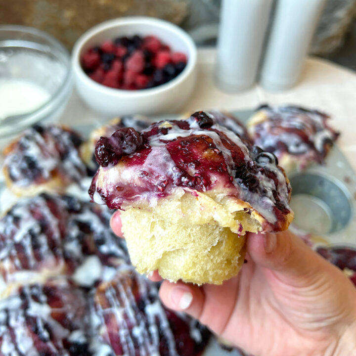a sourdough muffin with berries and vanilla glaze