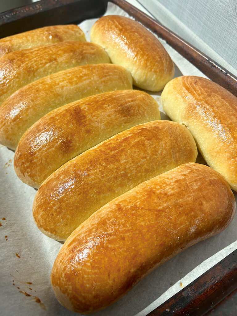brioche hot dog buns on a baking sheet