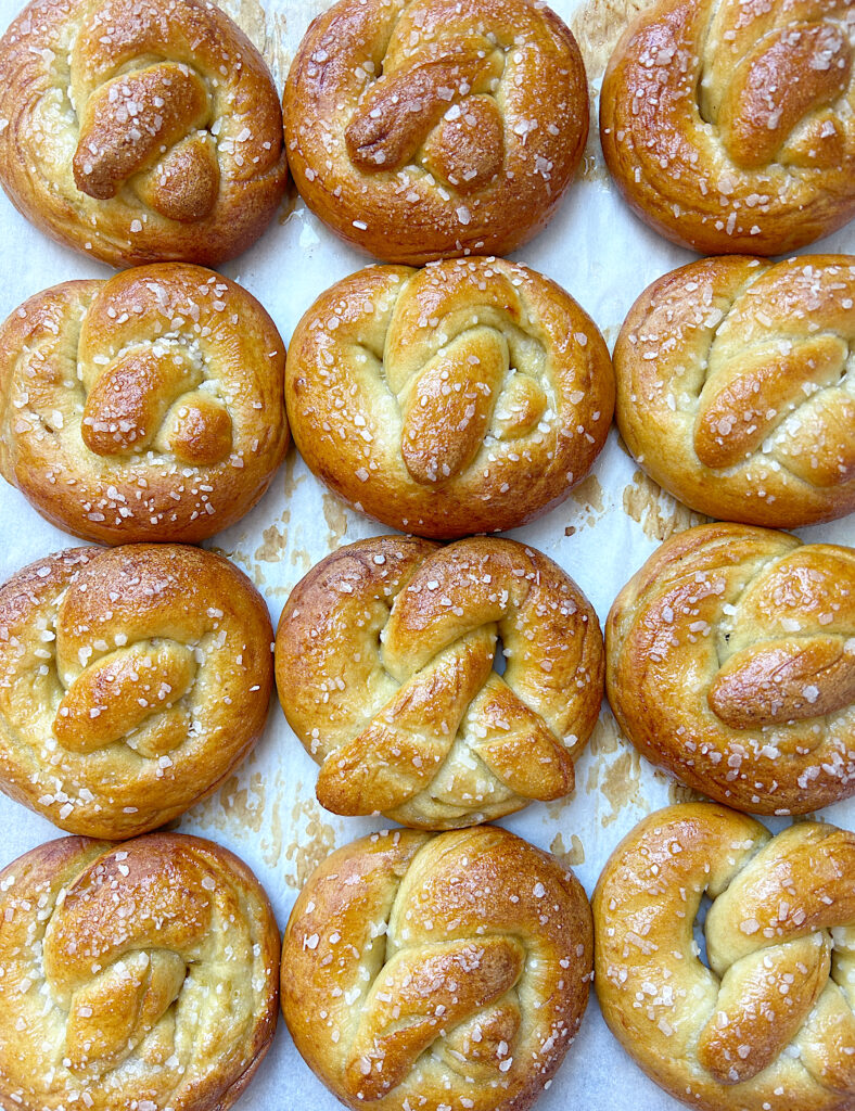 a baking sheet full of golden salted soft pretzels