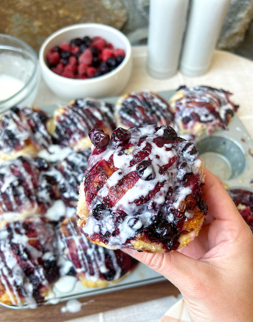 a sourdough focaccia muffin with berries and vanilla glaze