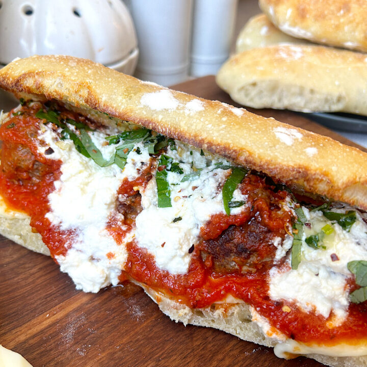 a sub sandwich filled with meatballs, tomato sauce and mozzarella