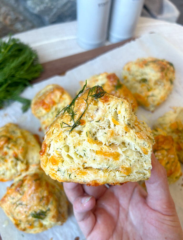 a hand holding a cheese biscuit