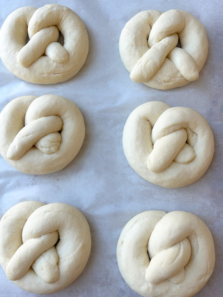 unbaked soft pretzels on a baking sheet