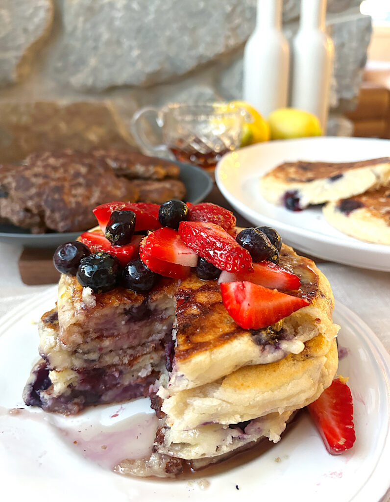 a stack of berry pancakes with a bite missing