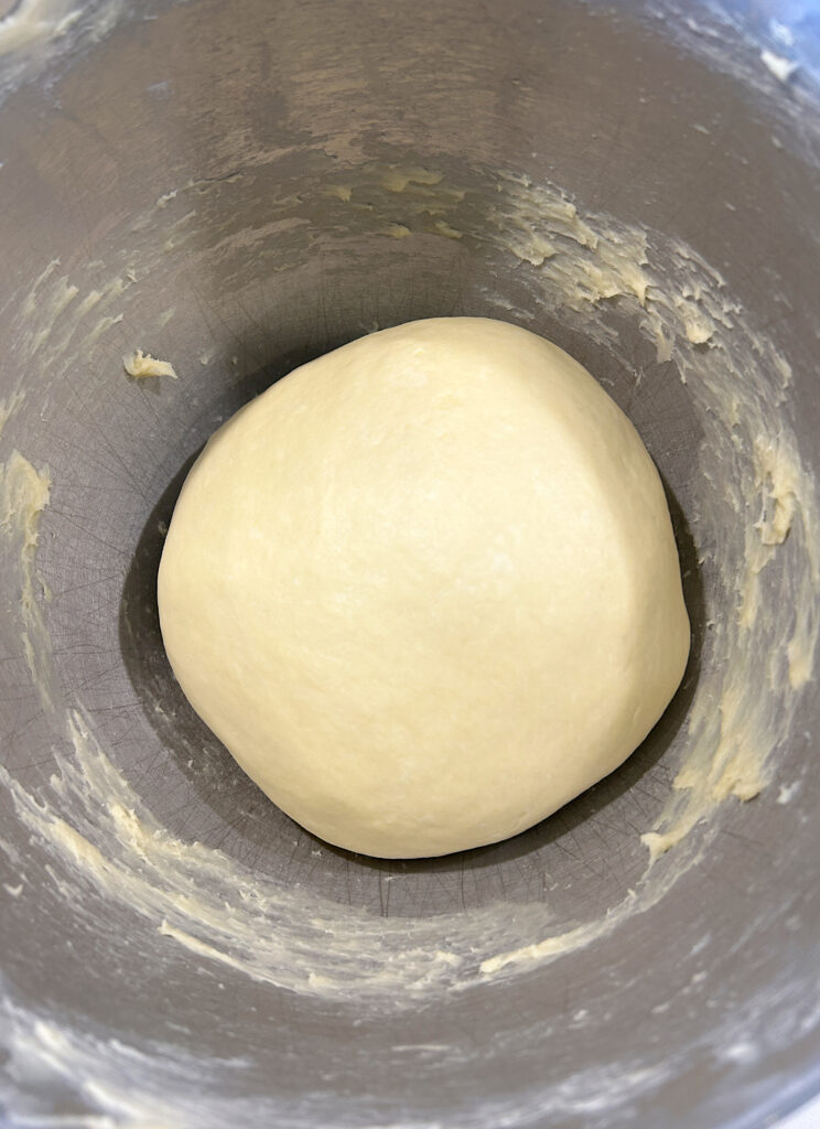 a stainless steel bowl full of bread dough