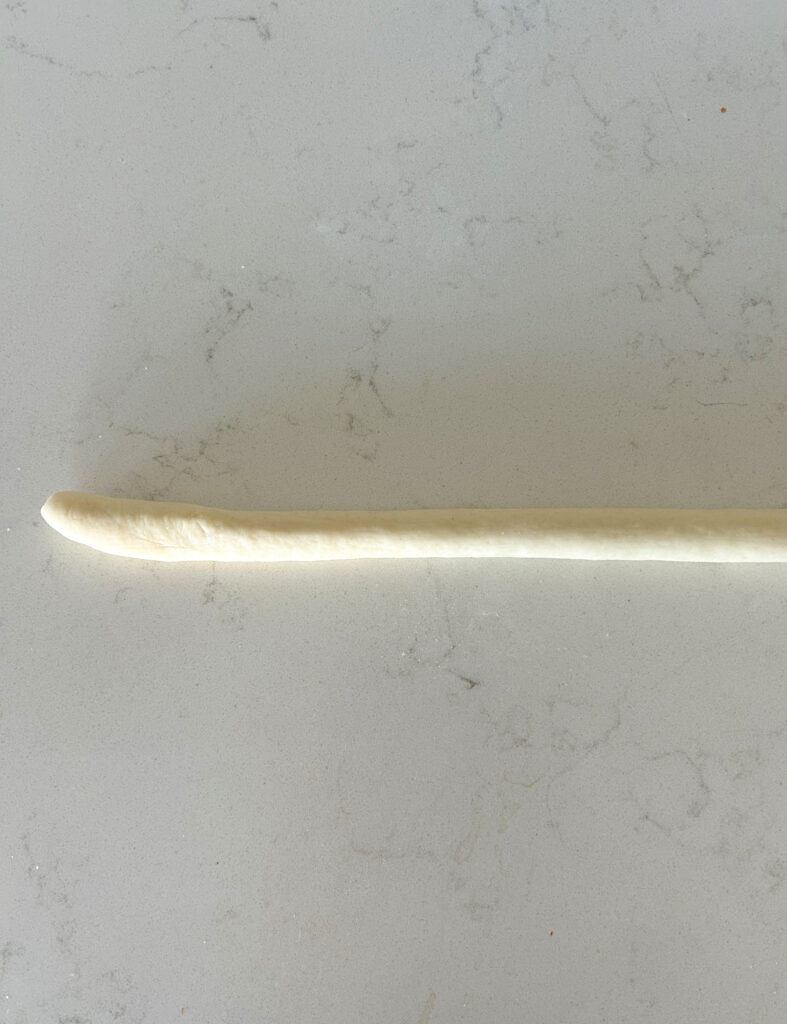 a log of dough on a white counter
