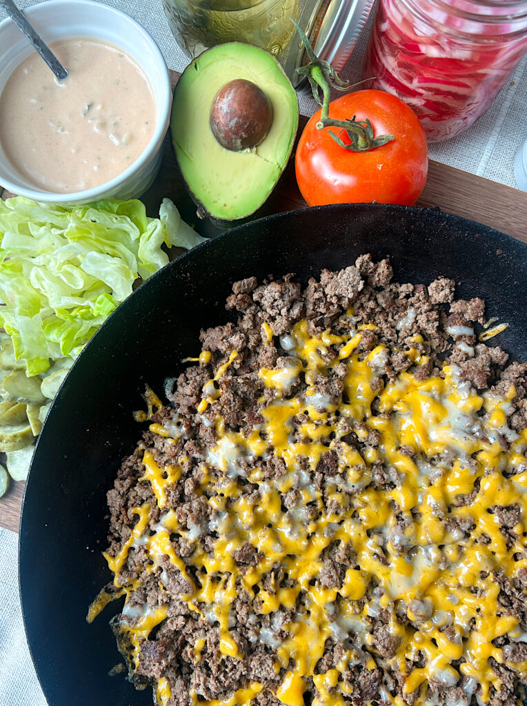 a skillet with ground meat and cheddar cheese