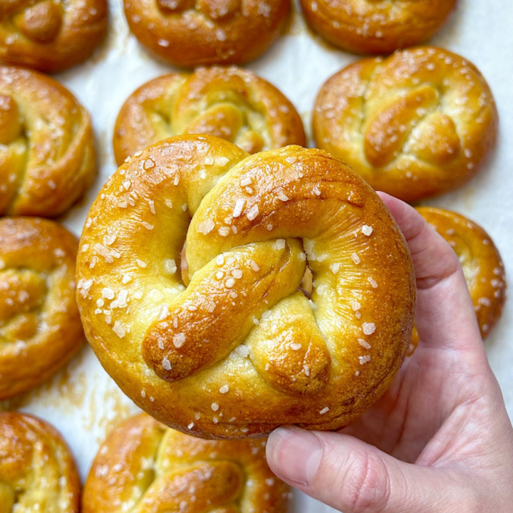 a golden brown soft pretzel with flaky salt on it