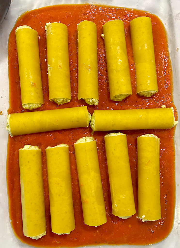 stuffed pasta tubes, on top of tomato sauce