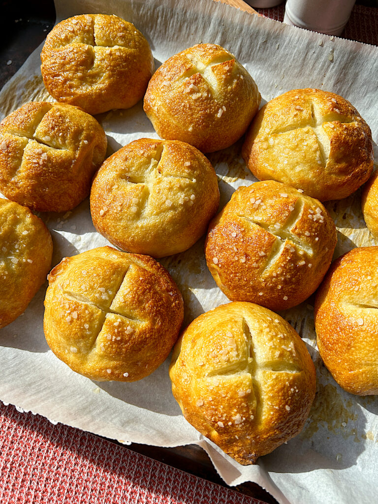 a tray of golden flaky salt pretzel buns