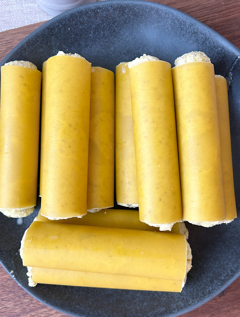 a plate of cannelloni pasta stuffed with ricotta