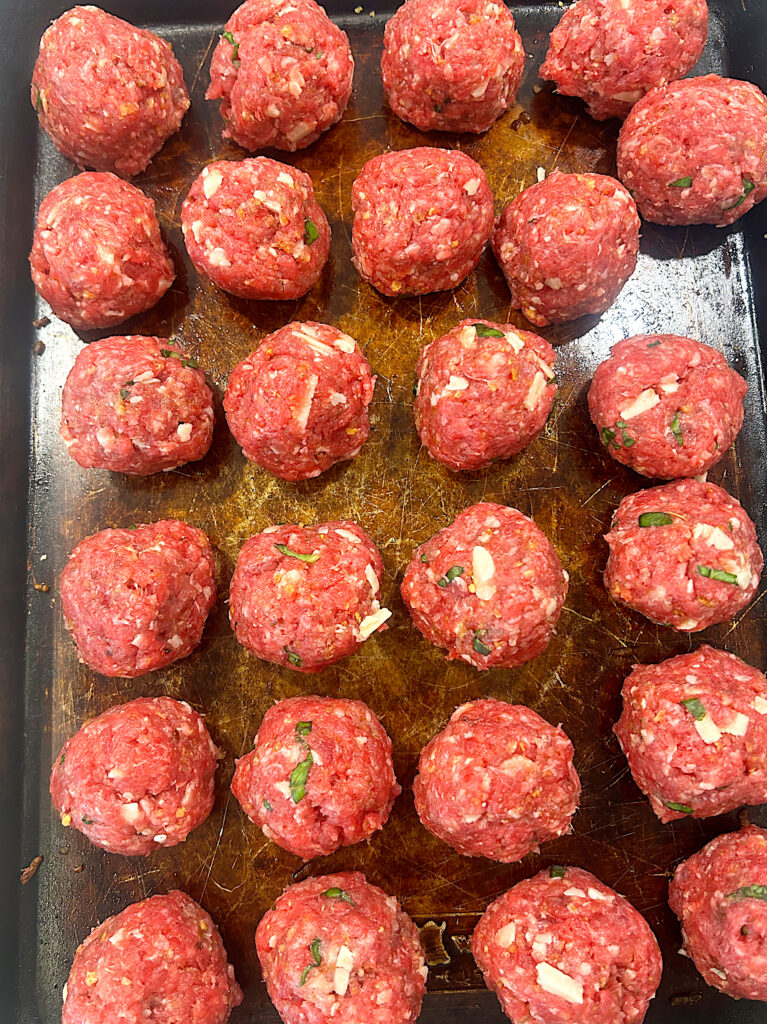 a tray of uncooked meatballs