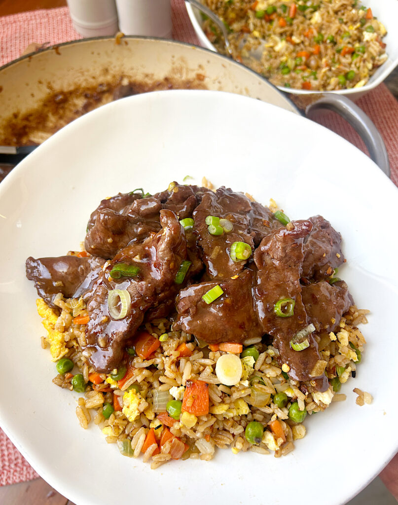 a white bowl of fried rice with venison stir fry on top