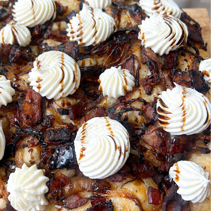 a focaccia bread topped with bacon, onions and dollops of ricotta cheese