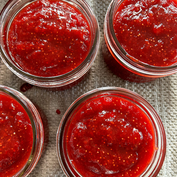 jars of strawberry jam without lids on them