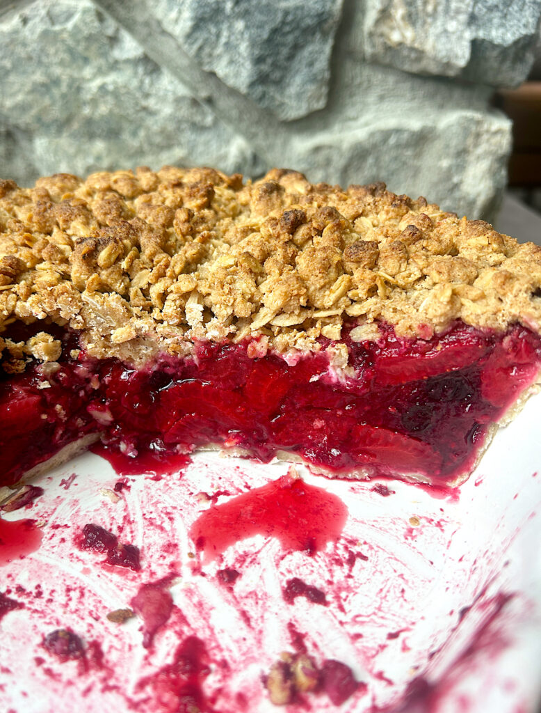 half of a berry crumble pie in a pie plate